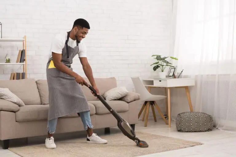 man cleaning a carpet with a vacuum cleaner