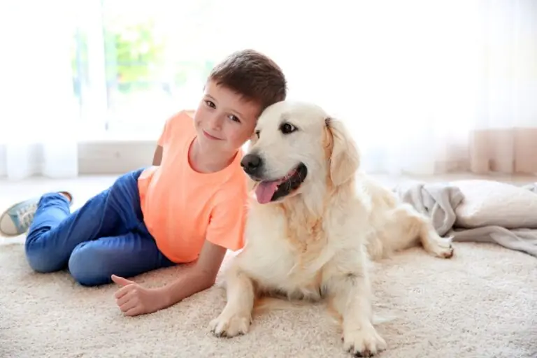 boy and dog lying on carpet at home